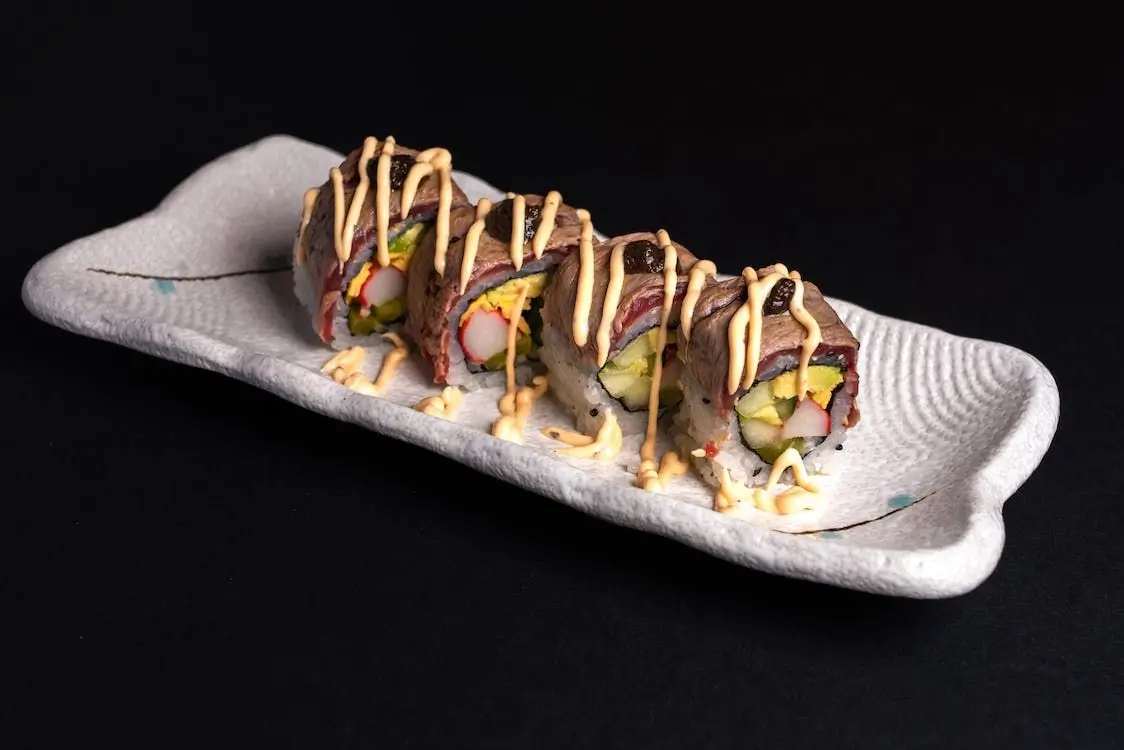 Beef Veggie Sushi Roll features sushi rolls with vegetables inside, topped with slices of beef and drizzled with sauce at Sushi Town, a Japanese restaurant in San Jose