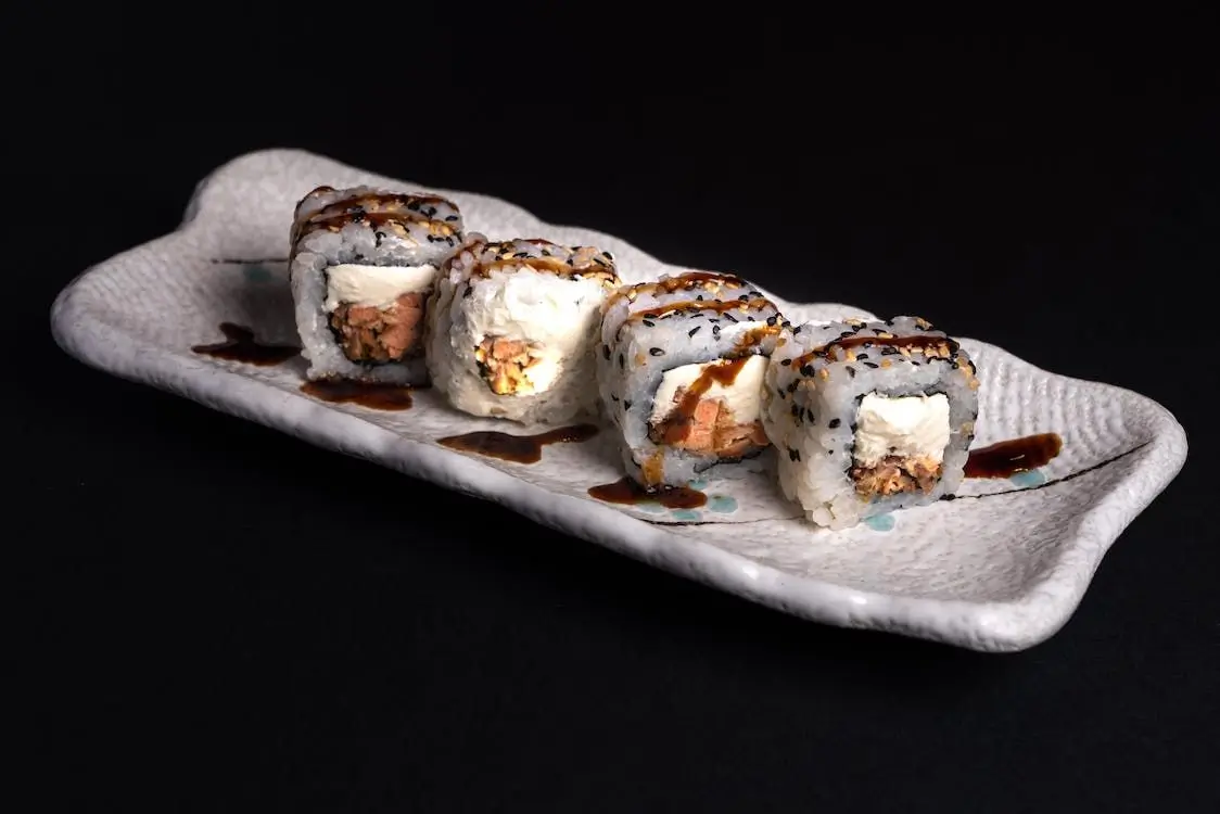 Salmon Cream Cheese Sushi Roll has salmon and cream cheese inside, topped with sesame seeds and eel sauce at Sushi Town, a Japanese restaurant in San Jose